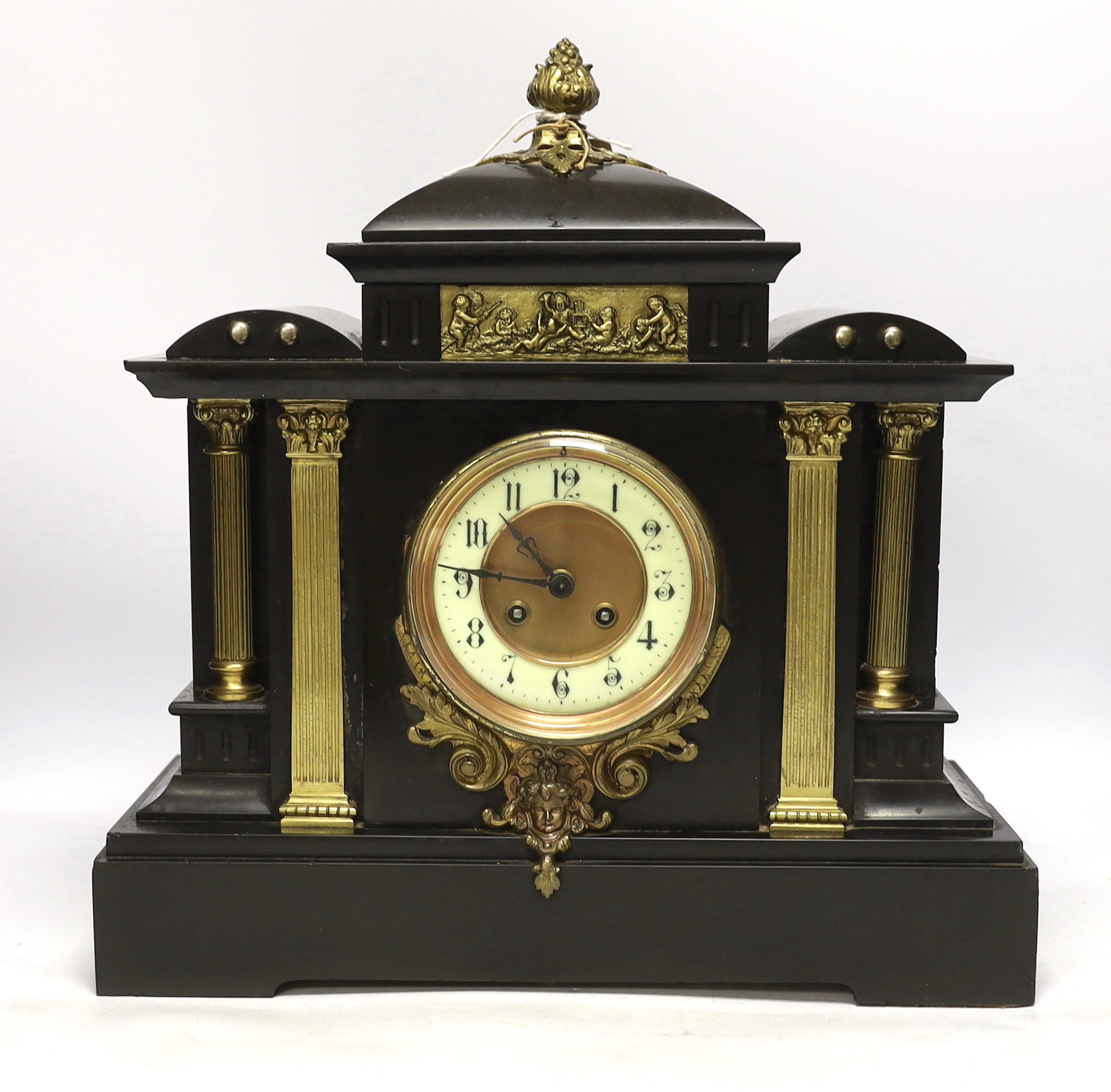 A black slate mantel clock with gilded pillars, striking on a coiled gong, 41cm high